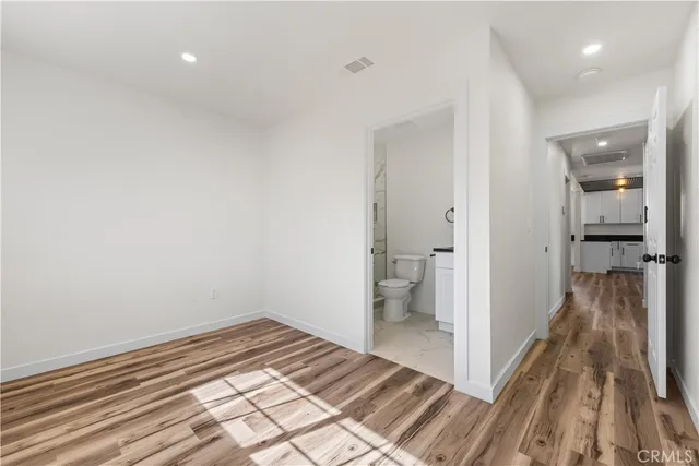 a view of a room with wooden floor and a bathroom