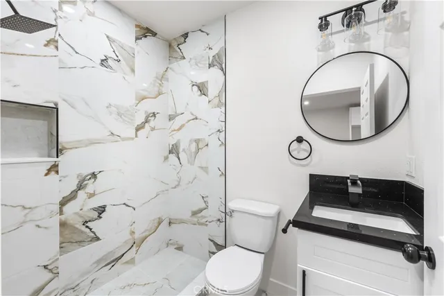 a bathroom with a toilet sink and mirror