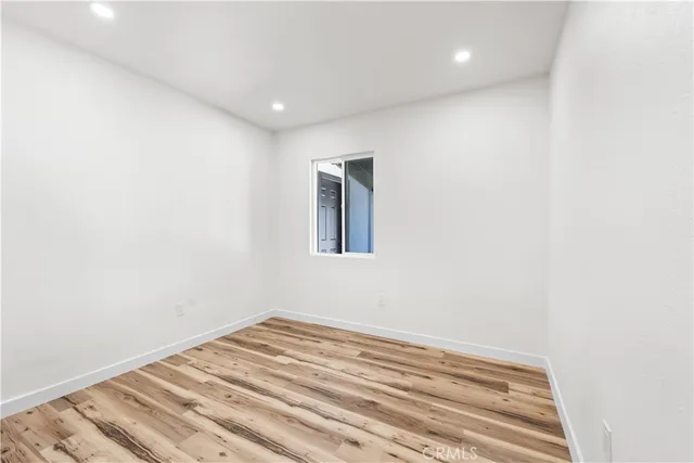 a view of a room with wooden floor and white walls