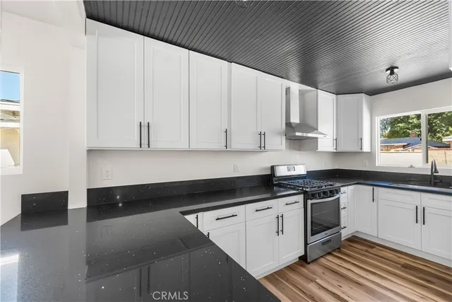 a kitchen with granite countertop white cabinets and white appliances