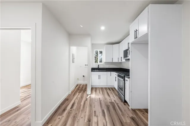 a kitchen with cabinets and a wooden floor