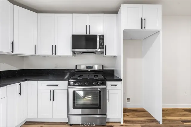 a kitchen with white cabinets and appliances