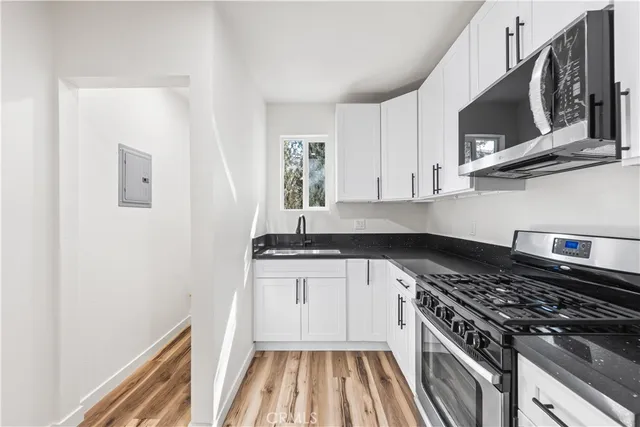 a kitchen with stainless steel appliances granite countertop a stove and a microwave