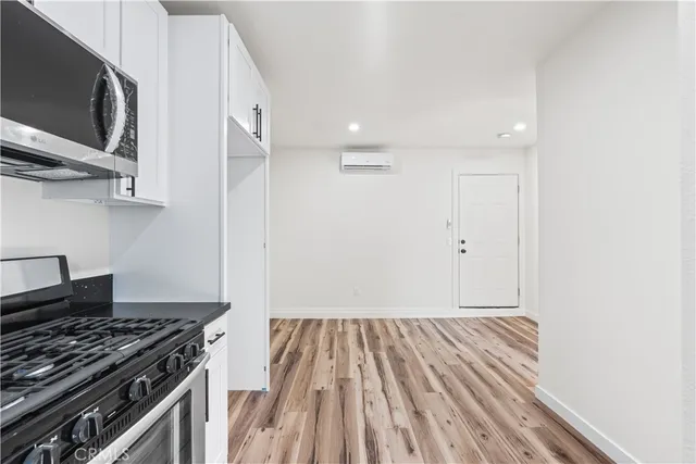 a kitchen with wooden floor and a stove top oven