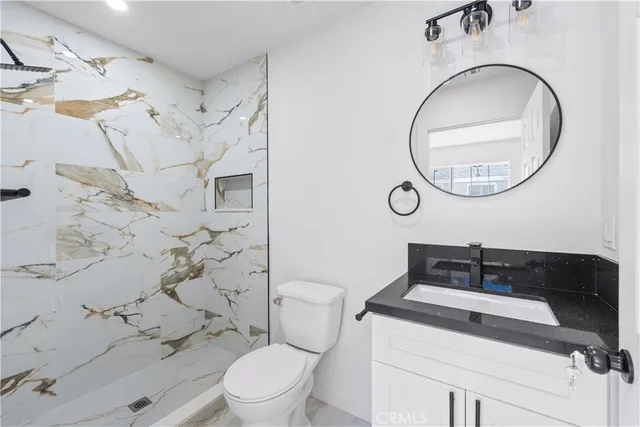 a bathroom with a sink mirror vanity and toilet