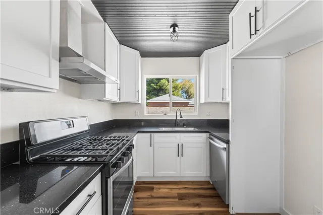 a kitchen with stainless steel appliances granite countertop a sink and a stove