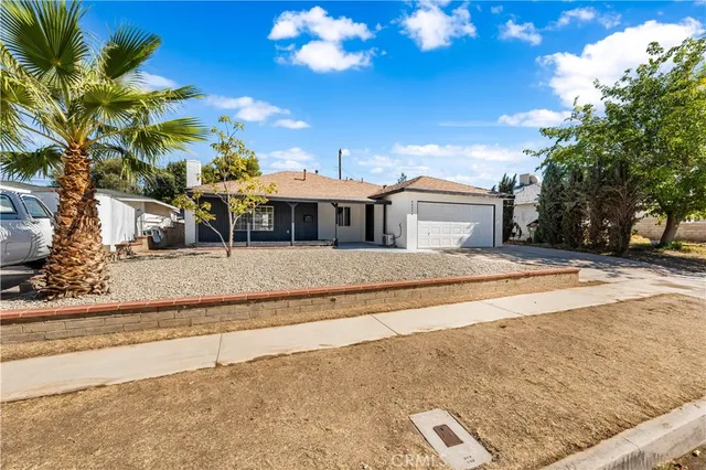 a view of a white house with a large tree