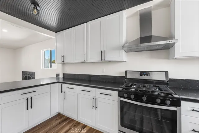 a kitchen with granite countertop white cabinets and stainless steel appliances