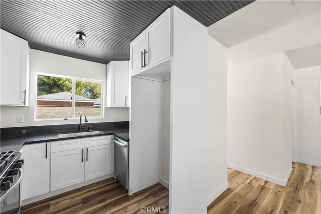 a kitchen with white cabinets and window