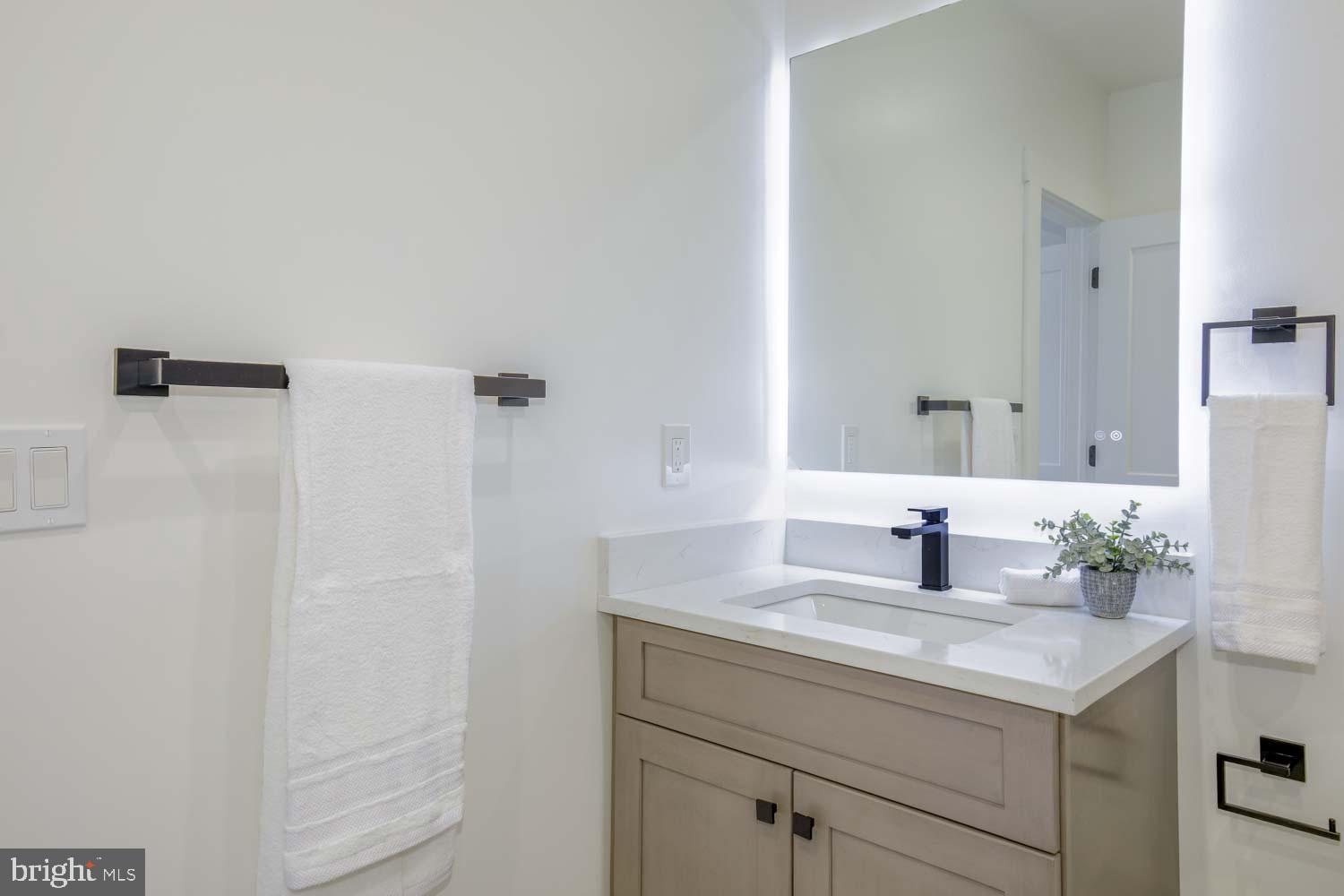 424 Taylor Street Northwest, Unit 2 Washington, DC 20011 - Photo 38 of 49 a bathroom with a granite countertop sink and a mirror