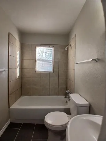 a bathroom with a toilet a sink and bathtub