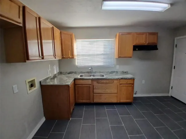 a kitchen with granite countertop a stove a sink and a microwave
