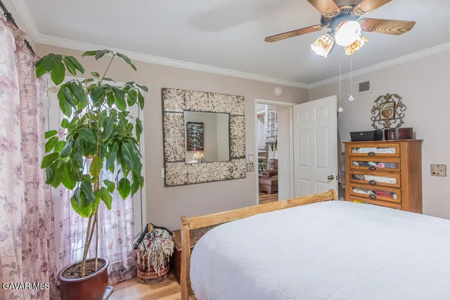 a bedroom with a bed potted plant and a chandelier