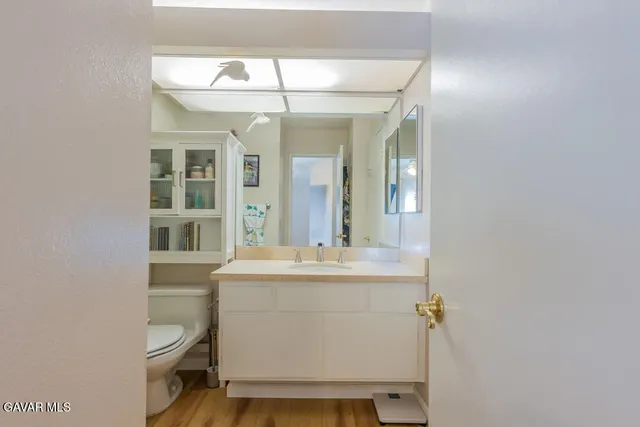 a bathroom with a sink a toilet and a mirror