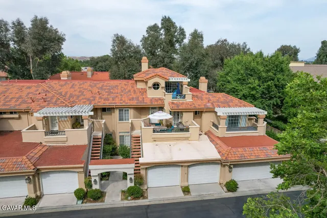 an aerial view of a house with yard and mountain view in back