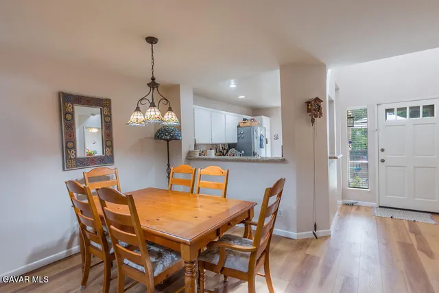 a dining room filled chandelier and wooden floor