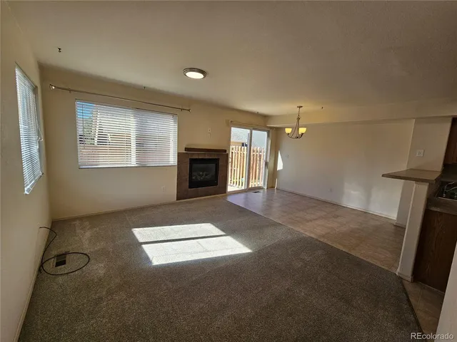 a view of an empty room with a fireplace and a window