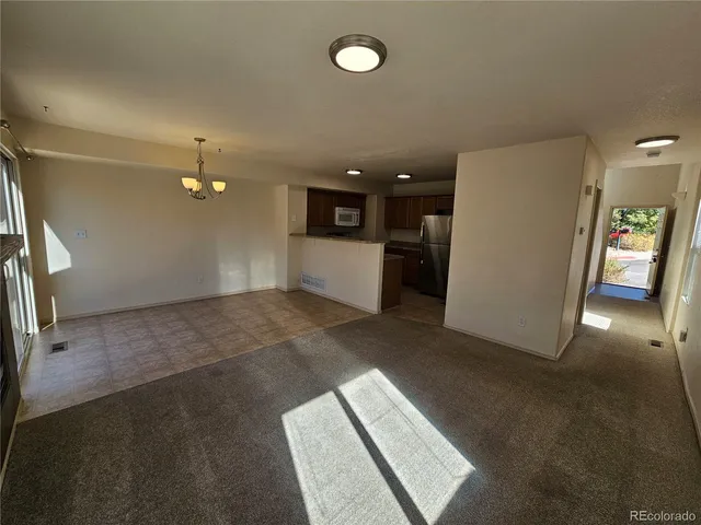 a view of a kitchen with a sink and refrigerator