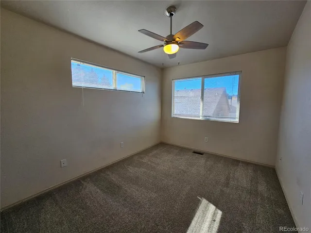 an empty room with closet and a chandelier fan