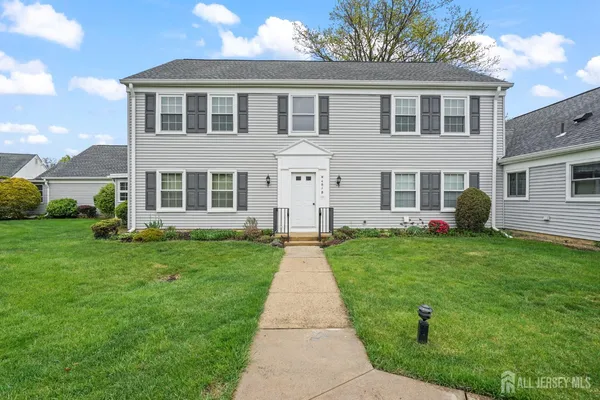 a front view of a house with a garden and plants