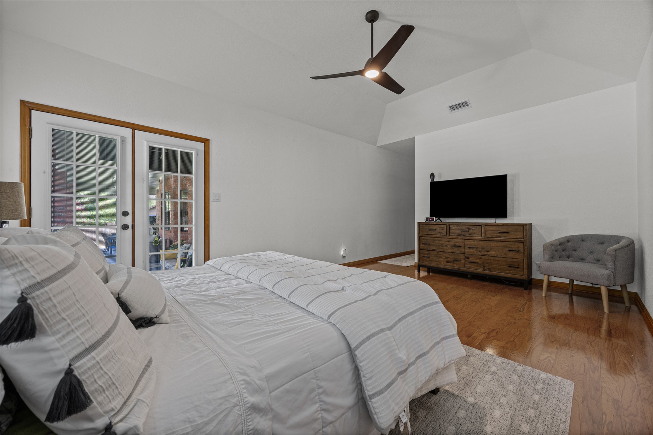 2000 Spinel Road Pflugerville, TX 78660 - Photo 16 of 31 French doors open to an inviting outdoor space from this well-lit bedroom with rich hardwood flooring.