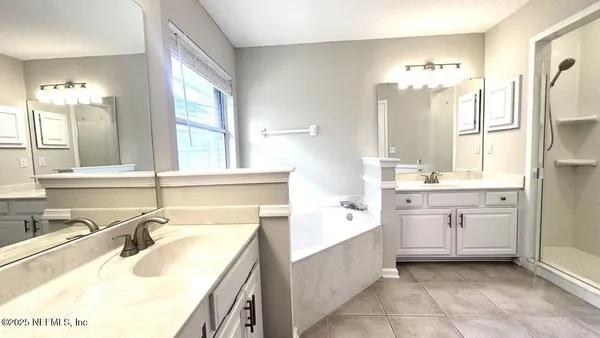 a bathroom with a tub sink and mirror