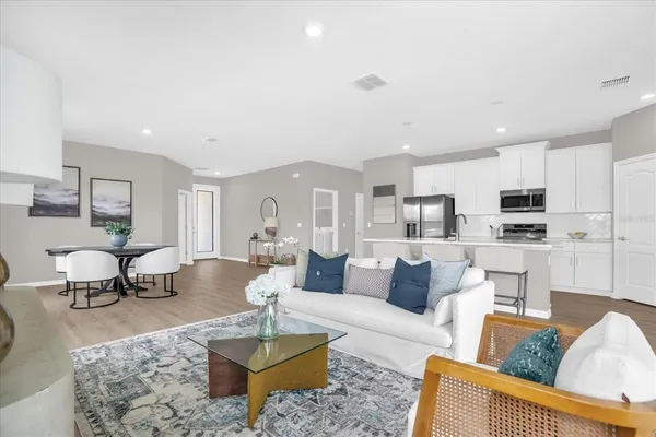 a living room with furniture and a view of kitchen