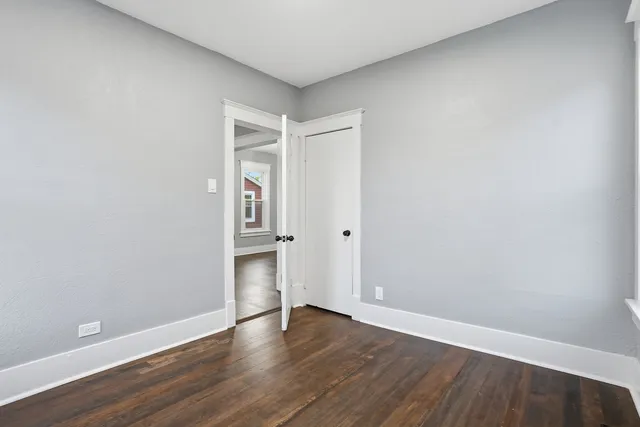a view of an empty room with wooden floor