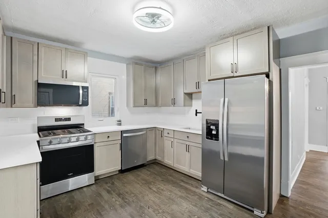 a kitchen with cabinets stainless steel appliances and a counter space