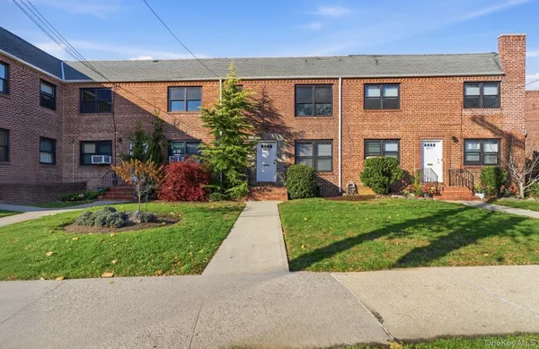 front view of a brick house with a yard