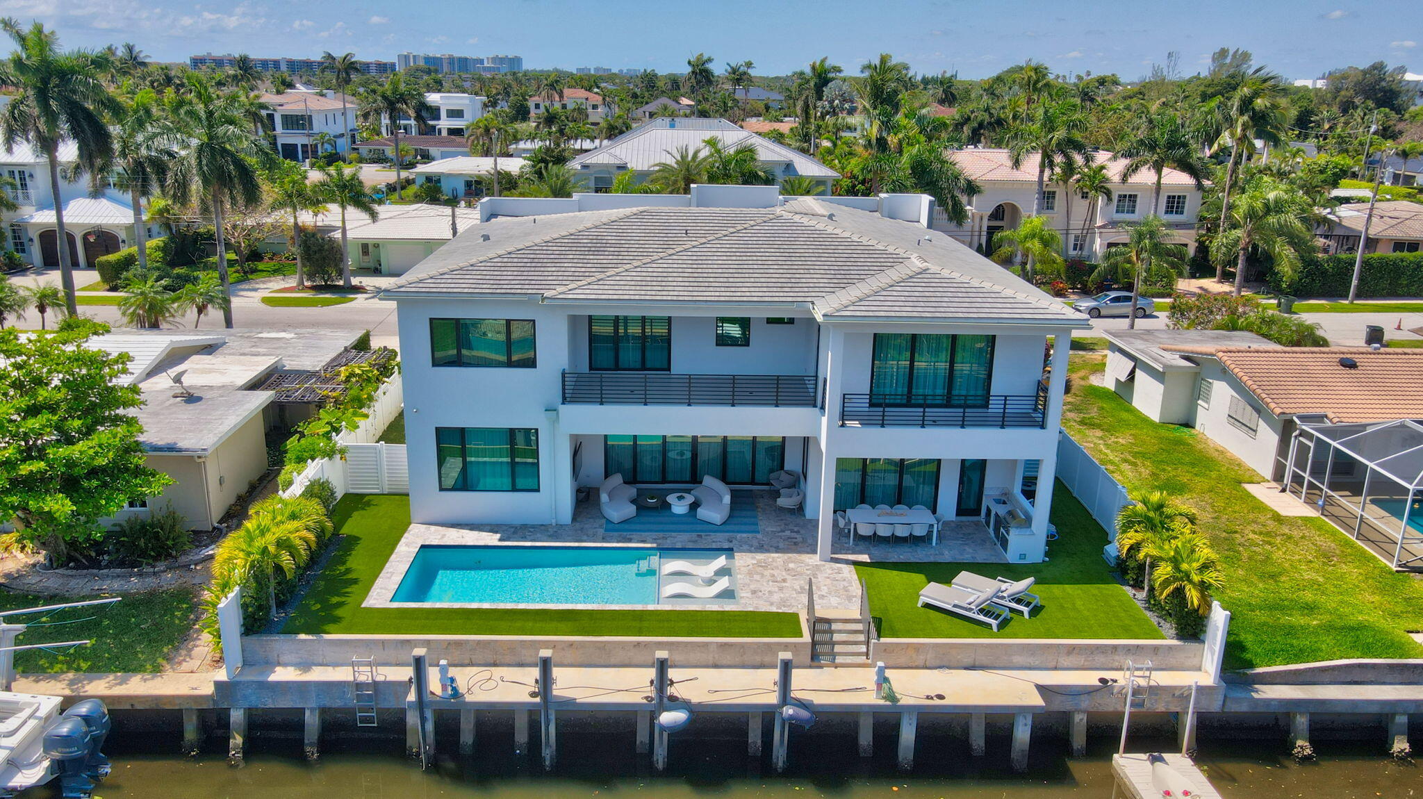 725 Northeast 71st Street Boca Raton, FL 33487 - Photo 60 of 66 a view of a house with a swimming pool and lawn chairs under an umbrella