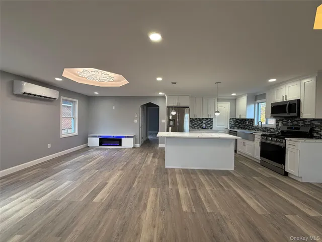 a large kitchen with stainless steel appliances kitchen island a large counter top a stove and a sink