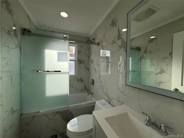 a bathroom with a bathtub shower sink vanity and toilet
