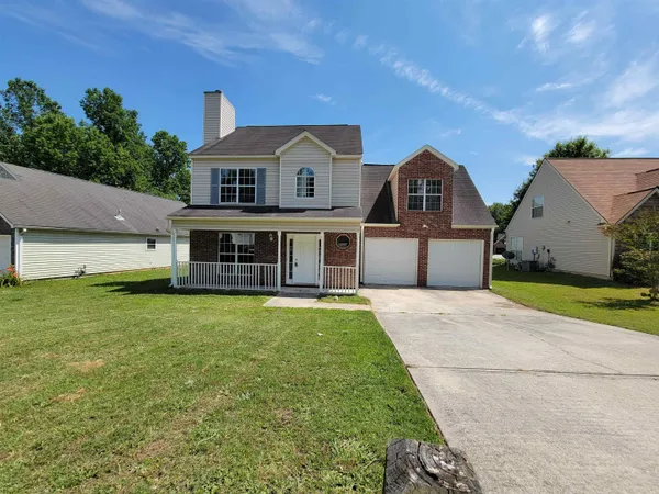 a front view of a house with a yard and garage