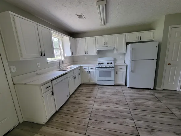 a kitchen with cabinets stainless steel appliances a sink and a window