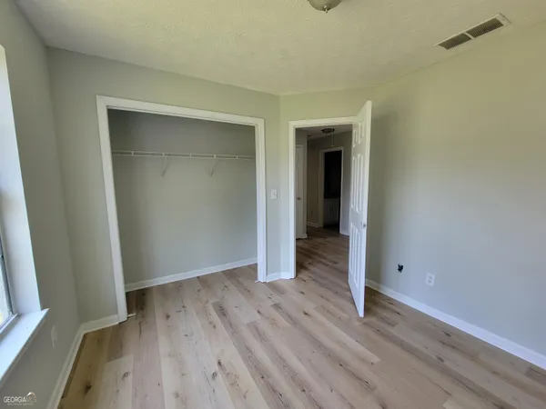 an empty room with wooden floor and closet