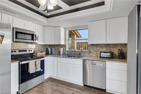 a kitchen with stainless steel appliances granite countertop a stove sink microwave and cabinets