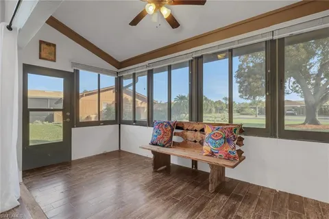 a living room with furniture and floor to ceiling windows