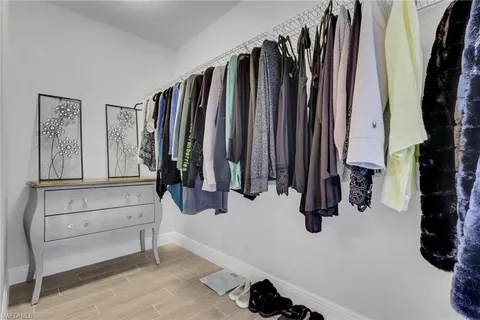 a view of walk in closet with clothes and shoes