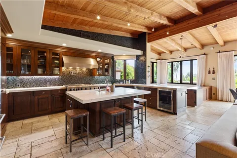 a spacious bedroom with a bed a fireplace and a flat tv screen