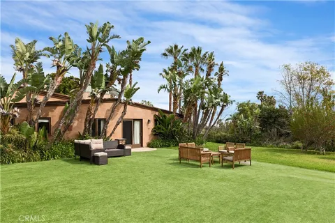 a view of a patio with a table and chairs under an umbrella with wooden fence