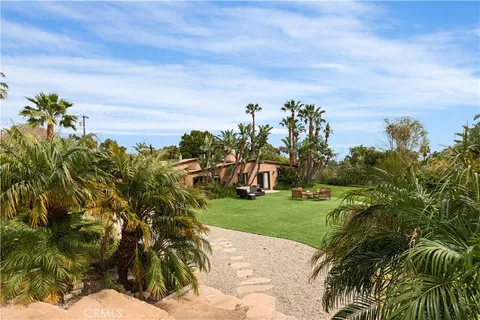a front view of a house with a yard and potted plants