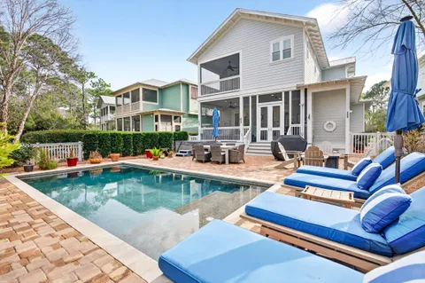 a view of a patio with couches chairs and swimming pool with a yard