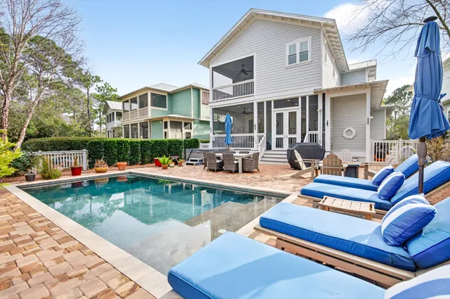 a view of a patio with couches chairs and swimming pool with a yard