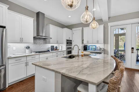 a living room with furniture a large window and wooden floor