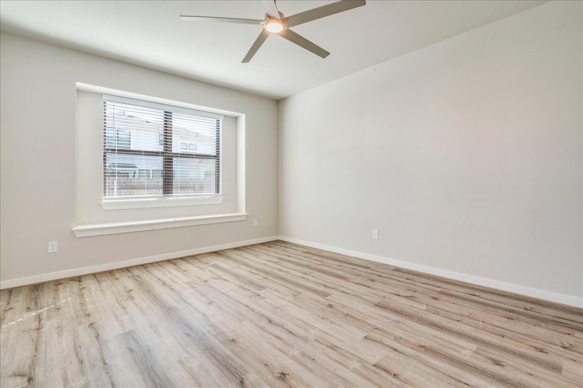 144 Threshing Road, Unit A Buda, TX 78610 - Photo 14 of 35 Primary bedroom located on main level and features a window seat, ceiling fan and LVP flooring.