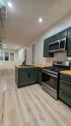 a kitchen with stainless steel appliances kitchen island granite countertop a stove and a sink