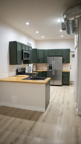 a kitchen with a refrigerator and a stove top oven