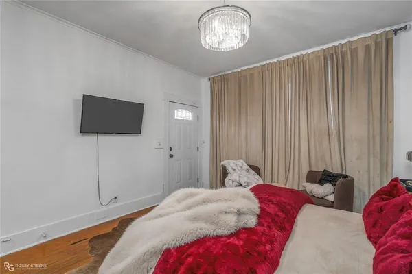 a bedroom with a large bed and a flat tv screen
