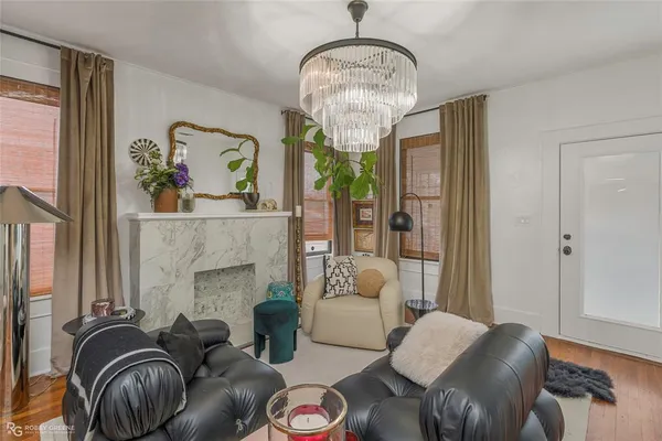 a living room with furniture chandelier and a fireplace